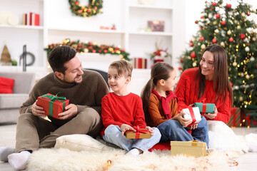 Happy family with Christmas gifts on floor in festive decorated room