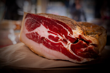 Fatias de presunto com queijo ao fundo no mercado
