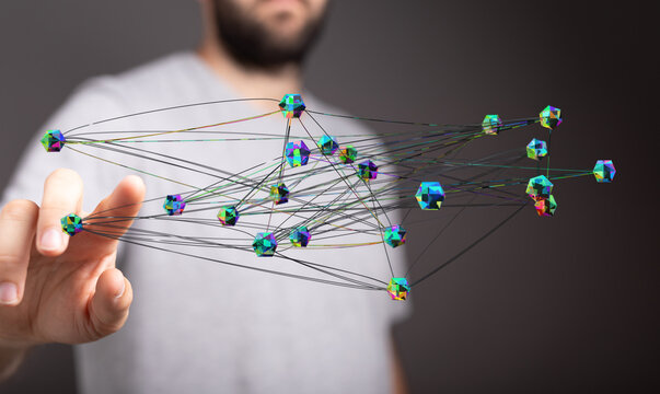 Abstract image showing a hand connecting to a network of colorful 3D geometric shapes representing data flow. C