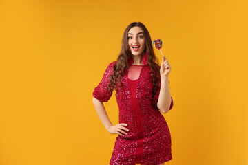 Beautiful woman with lollipop on orange background, space for text