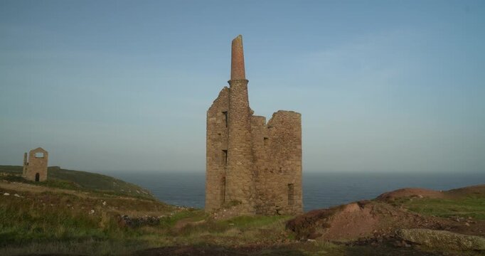 Old stone ruins of engine houses at Botallack mines on the Atlantic coast of Cornwall, England, UK during golden hour at sunrise