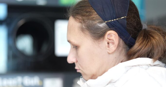 Woman returns plastic bottles to a reverse vending machine, reducing waste at midday