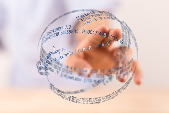 Abstract image of a person touching a digital sphere filled with code, representing the interconnectedness of information and technol