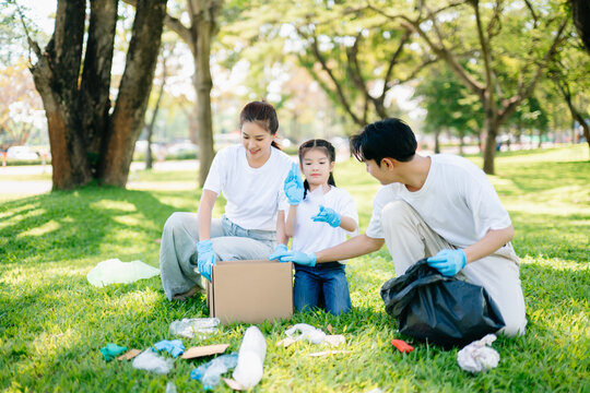Joyful family volunteering to clean a park together. A heartwarming outdoor scene promoting teamwork, love, and environmental awareness in a green lifestyle. - Powered by Adobe