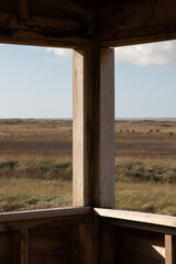 Vue de l'intérieur d'un observatoire sur la côte de jade, qui donne vue sur un environnement naturel et sauvage avant d'atteindre les dunes et la mer