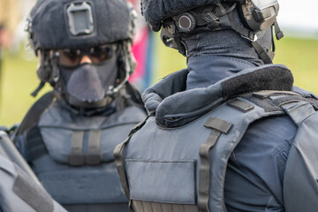 police officers are among a crowd of people in equipment with helmets and masks on their faces.