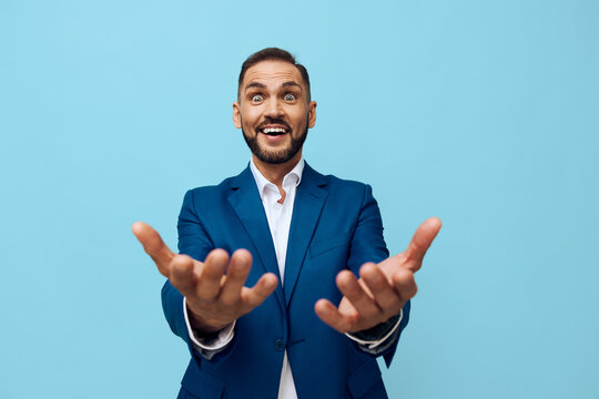 A professional man in a blue suit reaches forward with a welcoming smile, isolated against a vibrant blue background, conveying confidence, motivation, and optimistic business energy.