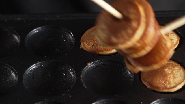 Man chef use chopsticks to pack delicious mini pancakes in the box