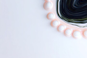 A close-up abstract view of swirling dark and light colors next to a line of white spheres with pink outlines on a white surface.