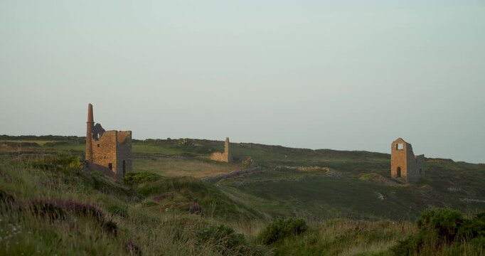 Old stone ruins of engine houses at Botallack mines on the Atlantic coast of Cornwall, England, UK during golden hour at sunrise