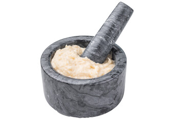 Freshly prepared cream sauce (horseradish or garlic aioli) being blended in a dark marble mortar and pestle. Homemade cooking process.