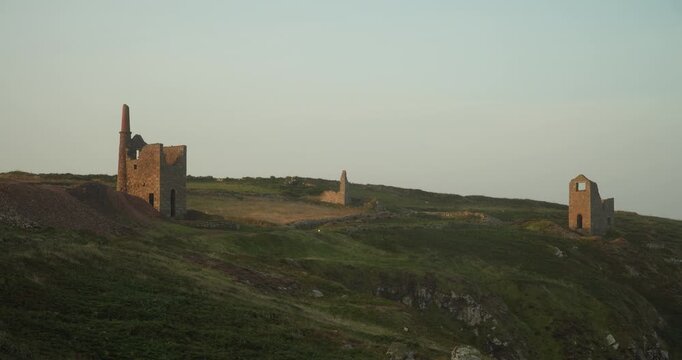 Old stone ruins of engine houses at Botallack mines on the Atlantic coast of Cornwall, England, UK during golden hour at sunrise