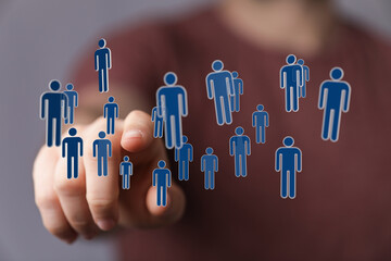 Hand pointing at floating digital human icons. Concept of connection, community, and networking in a collaborat