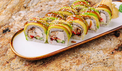 Delicious sushi rolls with avocado and chicken served on a plate