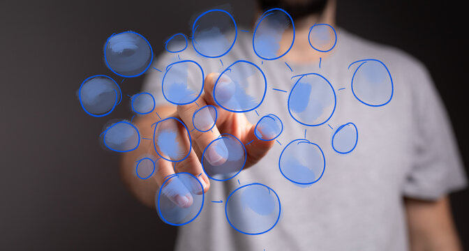 Human hand interacts with an abstract digital network of connected blue circles, symbolizing interconnected ideas, data, and communication. - Powered by Adobe