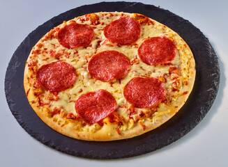 Pizza mit Salami auf Schiefer, Topshot, Italien, Salamischeiben, isoliert, Käse, 