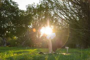 Woman practicing yoga exercises outdoors in park