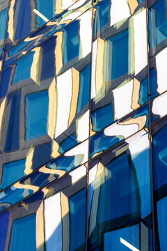 Architecture detail featuring modern facade geometry and rhythmic pattern elements interacting with reflection and texture to create a clean structured abstract composition