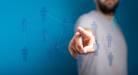 Abstract image showing a hand pointing to connected people icons on a blue background symbolizing technology an