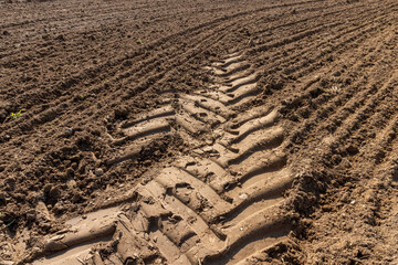 traces of a tractor on the soil of a field , soil in a field with traces of passing heavy agricultural machinery after tillage