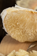 ripe and juicy grapefruit pulp broken into pieces, pieces and slices of ripe white grapefruit on the table