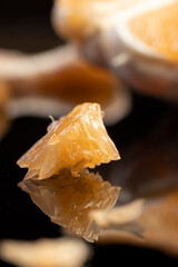 orange citrus on a black mirror surface, ripe and sweet and juicy citrus is reflected on the black surface, close up