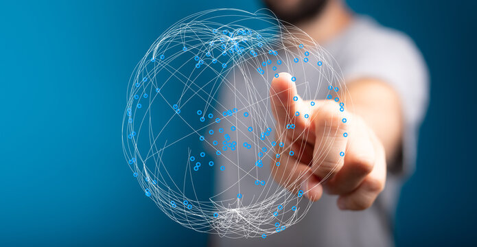 Abstract image showing a hand pointing at a glowing sphere representing global network connection and technological progress, innovat