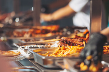 Delicious barbecue spread at a vibrant outdoor festival in the afternoon sun featuring various meats and sides