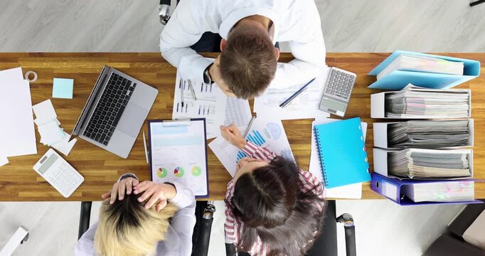 Office shows busy desk with reports laptops and folders. Manager reviews mistakes marking corrections while feeling frustrated and exhausted