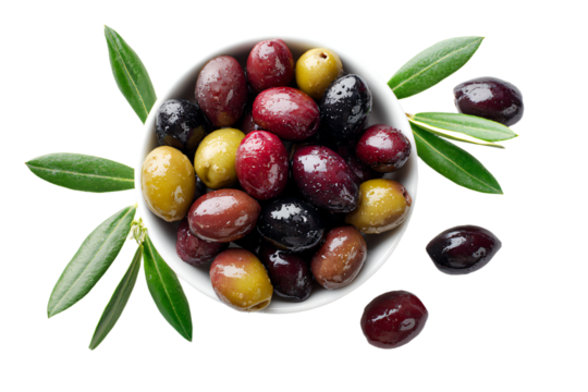 a bowl of olives with leaves on a white surface