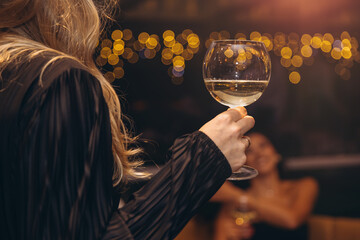 Woman holding white wine glass during party celebration
