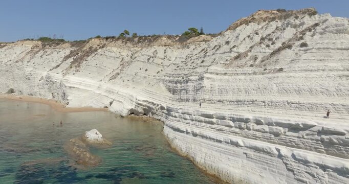 Aerial closeup of the Scala dei Turchi (Stair of the Turks or Turkish Steps) on the coast of Realmonte, near Agrigento, Sicily, Italy. It's a rocky cliff and tourist attraction. The sea is turquoise.