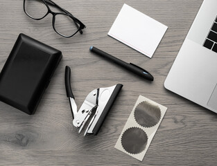 Embossing tool with foil sticker and office accessories on wooden desk