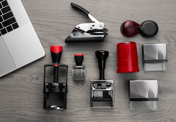 Office desk with stamps, ink bottles, laptop, and stationery top view