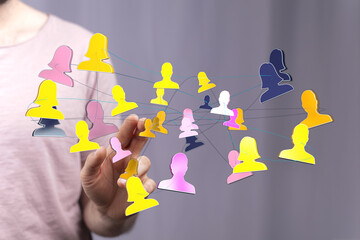 Concept of digital networking and community shown via hand interacting with a holographic representation of people connected together. Illustrat