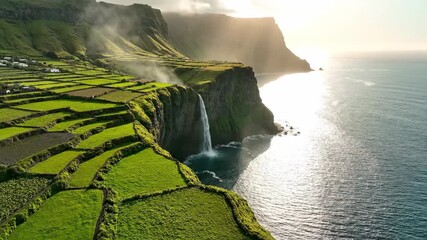 Flores island, azores coastal scene with lush terraced fields atop steep cliffs, waterfall plunging into the atlantic and golden sunlight glinting on the sea at close viewpoint - Powered by Adobe