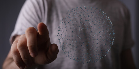 Close-up of a hand pointing towards a connected sphere of data points. Represents technology, connection, and futuristic concepts.
