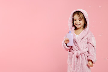 Cute girl in bathrobe with cosmetic product on pink background. Space for text