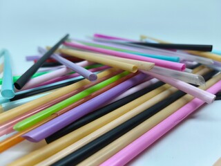 Fototapeta premium Pile of Diverse Colorful Used Plastic Straws on a Light Surface