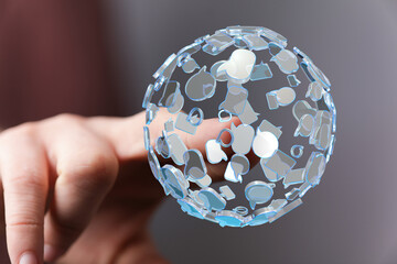 Hand holding a digital globe of social media icons. Represents global communication, networks, connections, and technology. Ideal for concepts l