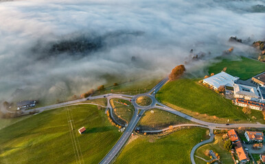 aerial view of the roundabout at B 308  at sunset with fog patches in Weiler-Simmerberg, Allgaeu, Bavaria, Germany