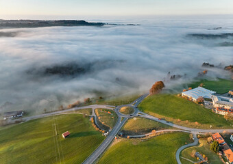 aerial view of the roundabout at B 308  at sunset with fog patches in Weiler-Simmerberg, Allgaeu, Bavaria, Germany