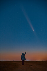 Silhouette of a Young Woman Against the Starry Sky, Observing the Celestial Event: Rare Comet ATLAS 2024 Visible at Night, Concept of Hope and Discovery