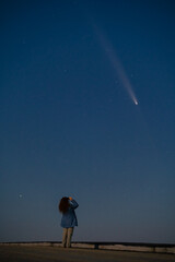 Silhouette of a Young Woman Against the Starry Sky, Observing the Celestial Event: Rare Comet ATLAS 2024 Visible at Night, Concept of Hope and Discovery
