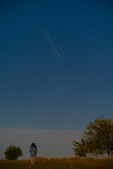 Silhouette of a Young Woman Against the Starry Sky, Observing the Celestial Event: Rare Comet ATLAS 2024 Visible at Night, Concept of Hope and Discovery