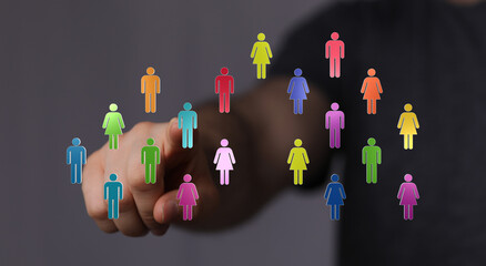 Hand pointing at colorful digital people icons, representing social networking, communication, teamwork, and connectivity. Symbolic of communiti