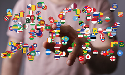 A hand touching a collection of various country flags. This image is suitable for international...