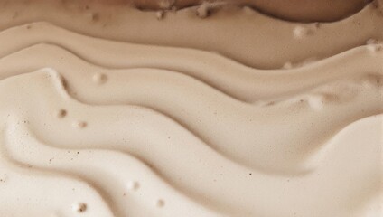 Abstract wavy pattern of various shades of brown and beige liquid foundation or paint.