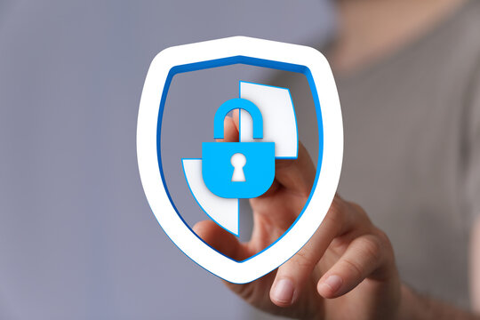 Concept of cybersecurity, data protection, privacy, and safety. Hand touching a shield icon with a lock. Illustrating digital securit