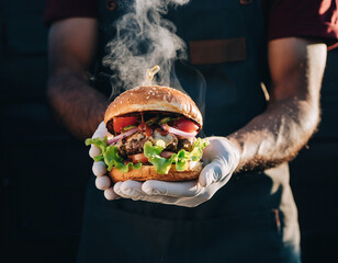  close up of hot burger serve by chef dark background